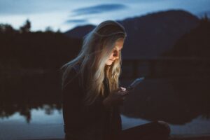 oklahoma TCPA telemarketing telemarketers girl with blonde hair looking at phone