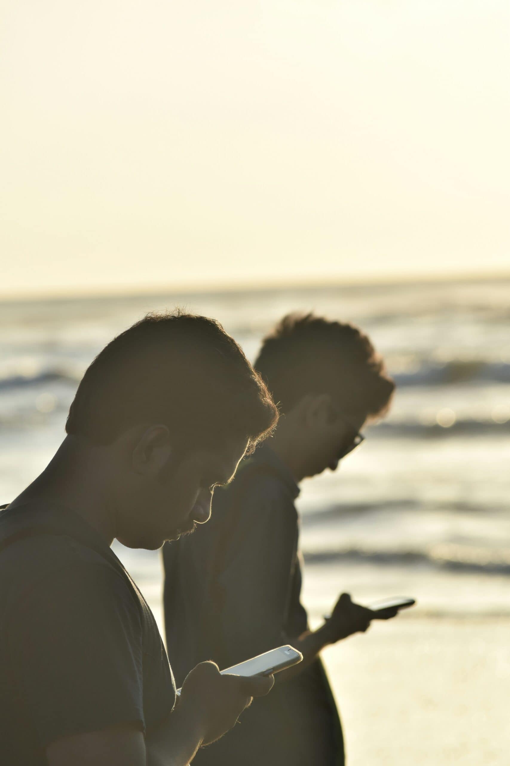 two guys looking at their phone on the beach california state wiretap data and privacy laws california beach