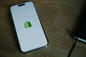 shopify green bag logo on the background of a cell phone on a wooden table TCPA claim