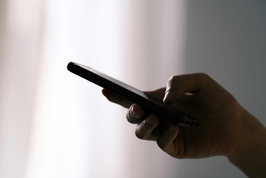 man holding phone campaign registry TCPA telemarketing