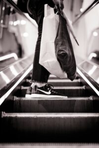 person on escalator with shopping bags black and white photo guy in mall pixel tracking