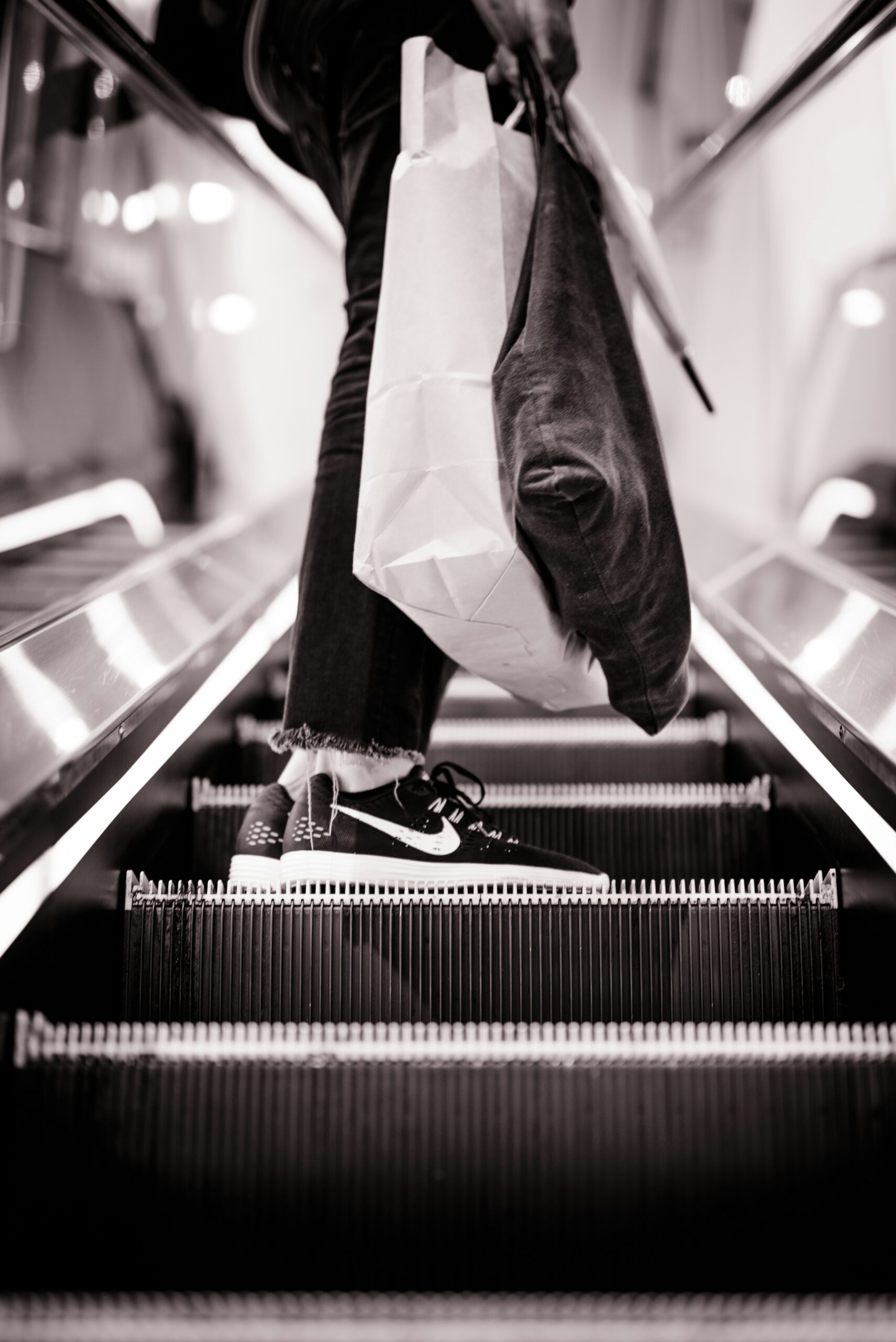 person on escalator with shopping bags black and white photo guy in mall pixel tracking