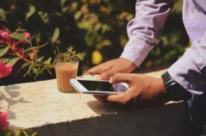 man holding phone outside in rose garden TCPA liability telemarketing telemarketer DNC list