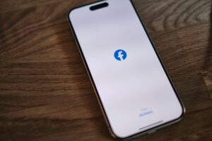 facebook logo on a cellphone on a wood table