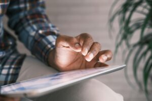 daniels law lawsuit man using an ipad wearing a plaid shirt