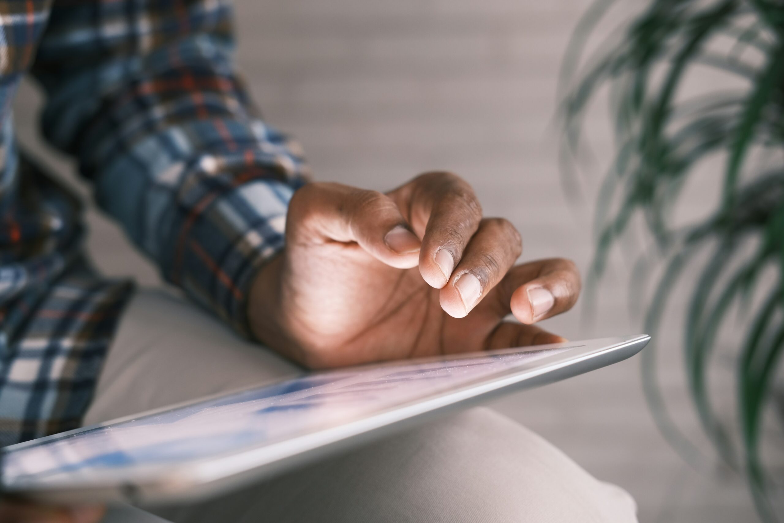 daniels law lawsuit man using an ipad wearing a plaid shirt