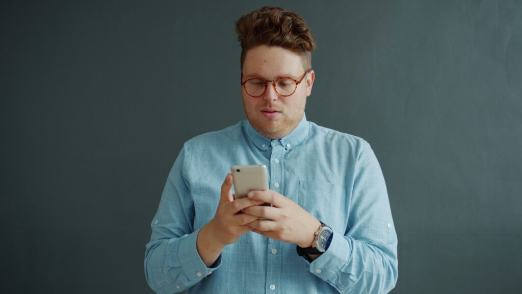 ugly redhead guy texting on his phone TCPA claim telemarketing telemarketers do not call list DNC