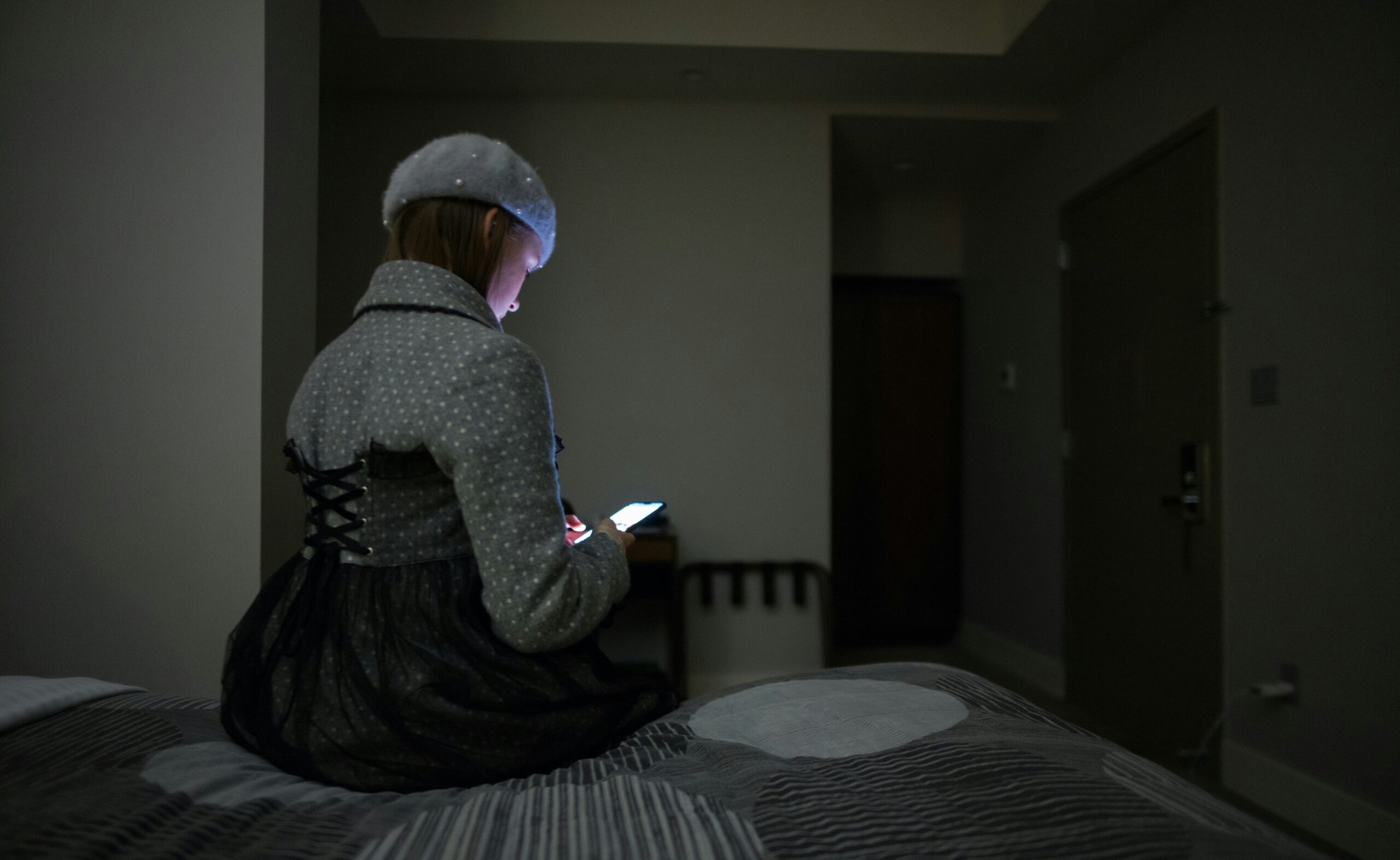 girl on phone on her bed at night telemarketing quiet hours