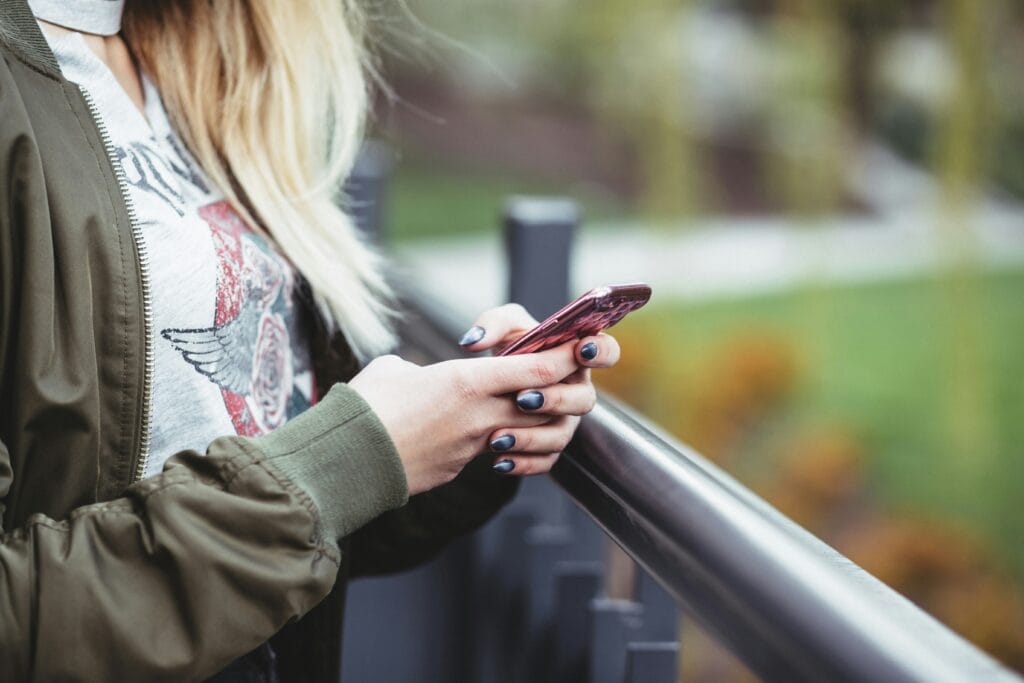 georgia tcpa girl with cool nails texting next to a bridge