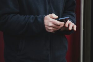 guy in black sweat shirt on his cell phone texting do not call list DNC