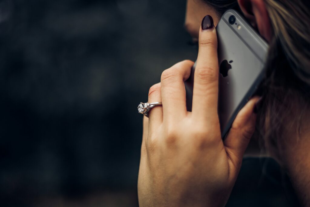 woman with wedding ring on taking a call on her cell phone do not call list