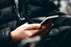 guy on phone in a black coat TCPA texts