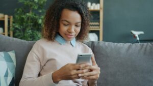 black girl texting on a couch tcpa texts